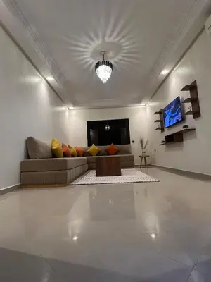 a living room with a couch and a tv at Appartement de luxe, Marrakech Menara in Marrakech