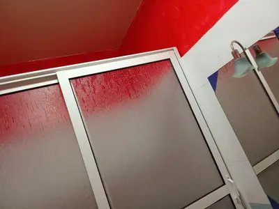a bathroom with a glass door and a red wall at شقة بغرفتين نوم لك بالكامل in Marrakech