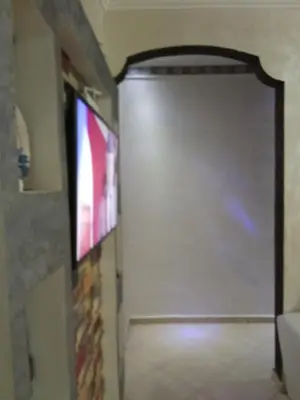 a room with a door with a tv and a wall at شقة بغرفتين نوم لك بالكامل in Marrakech
