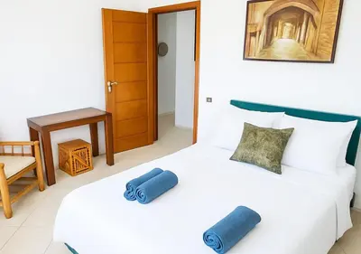 a bedroom with a white bed with blue pillows on it at Appartement moderne Guéliz, Centre Marrakech in Marrakech