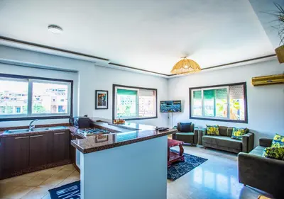 a kitchen with a bar and a living room at Appartement moderne Guéliz, Centre Marrakech in Marrakech