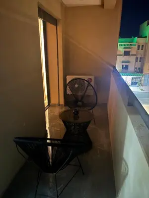 two black chairs sitting on a balcony with a window at Nice apartment in Marrakesh in Marrakech