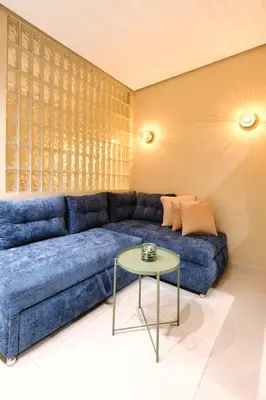 a blue couch in a living room with a table at Luxury Studios with Balcony in Marrakech