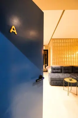 a living room with a couch and a letter on the wall at Luxury Studios with Balcony in Marrakech
