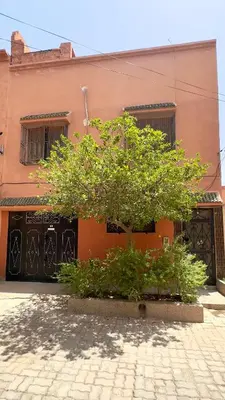 a tree sitting in front of a pink building at Cozy Garden Home in Marrakech in Marrakech