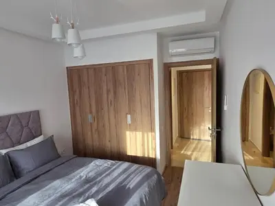 a bedroom with a bed and a mirror and a door at Appartement Résidence Noria Marrakech in Marrakech