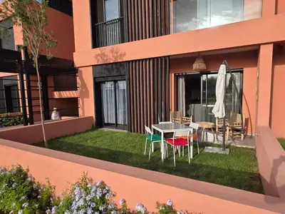 a patio with a table and chairs and an umbrella at Appartement Résidence Noria Marrakech in Marrakech