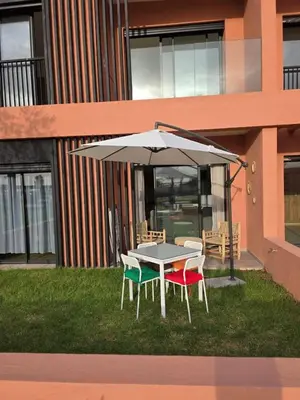 a table and chairs under an umbrella in the grass at Appartement Résidence Noria Marrakech in Marrakech