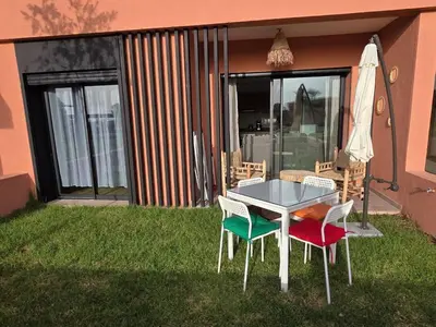 a table and chairs on the grass in front of a house at Appartement Résidence Noria Marrakech in Marrakech