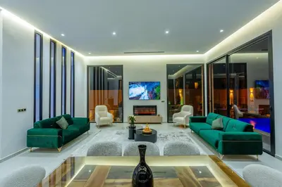 a living room with green couches and a tv at Villa iganis & Spa Marrakech in Marrakech