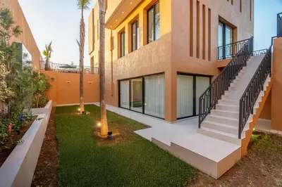 an exterior view of a building with a staircase and grass at Villa iganis & Spa Marrakech in Marrakech