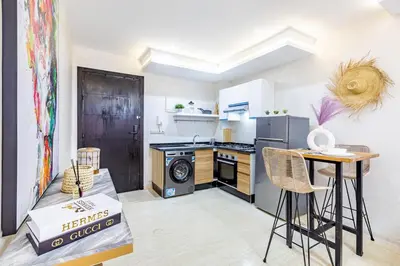 a kitchen with a stove and a table with chairs at Gueliz Comfort Corner Urban Apt in Marrakech