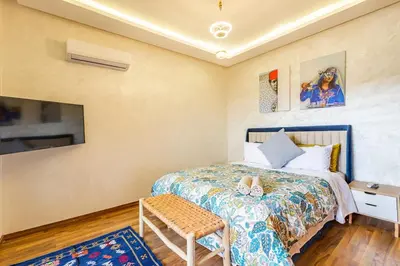 a small bedroom with a bed and a tv at Gueliz Comfort Corner Urban Apt in Marrakech