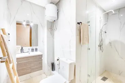 a white bathroom with a toilet and a sink at Gueliz Comfort Corner Urban Apt in Marrakech