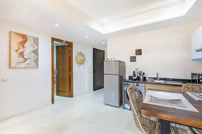 a kitchen with a table and a refrigerator at Gueliz Stay modern apt in Marrakech