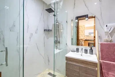 a bathroom with a shower and a sink and a mirror at Gueliz Stay modern apt in Marrakech