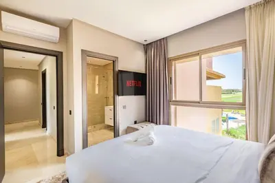 a bedroom with a white bed and a large window at Luxurious 3BR by to the pool in Marrakech