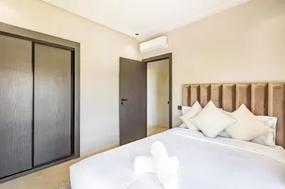 a bedroom with a white bed with white pillows at Luxurious 3BR by to the pool in Marrakech