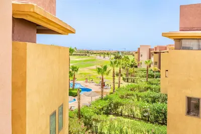a view of a resort with a pool and palm trees at Luxurious 3BR by to the pool in Marrakech