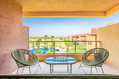 two chairs and a table on a balcony with a view at Luxurious 3BR by to the pool in Marrakech