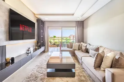 a living room with a couch and a tv at Luxurious 3BR by to the pool in Marrakech