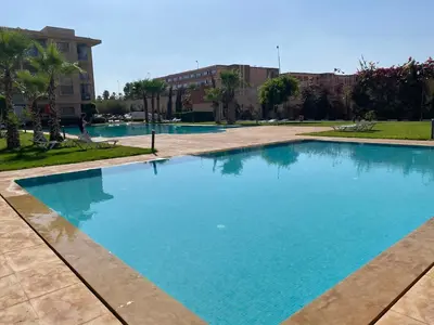 a large blue swimming pool in a park at Luxury apartment with 2 pools in Marrakech
