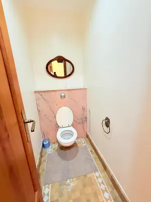 a bathroom with a toilet with a mirror on the wall at 2 - Bed Apartment with Garden & shared Pool - Moroccan - Modern Style in Marrakech