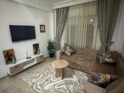 a living room with a couch and a flat screen tv at Modern One Bedroom Apartment in Central Gueliz Marrakech in Marrakech