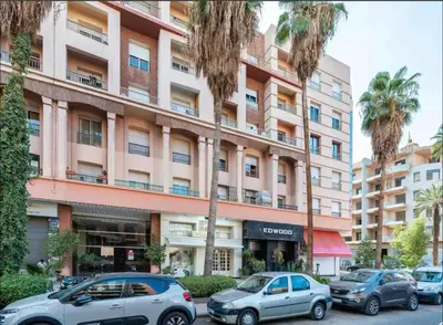 two cars parked in front of a large building at Modern One Bedroom Apartment in Central Gueliz Marrakech in Marrakech