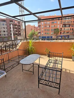 a patio with three chairs and a table on a roof at Appartement confortable et propre in Marrakech