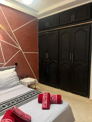 a bedroom with two beds with black cabinets and red pillows at Cozy Flat near Gueliz in Center in Marrakech