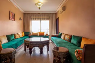a living room with a green couch and a table at Apartment for rent Wintering in Marrakech