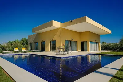 a house with a swimming pool in front of it at Villa Djamila Marrakech in Marrakech
