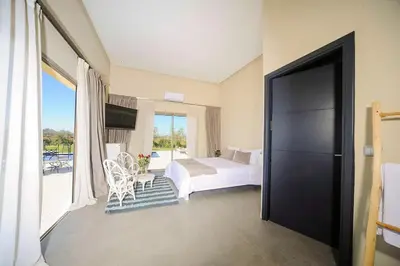 a bedroom with a bed and a balcony at Villa Djamila Marrakech in Marrakech