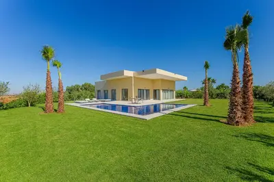 a large house with palm trees in front of it at Villa Djamila Marrakech in Marrakech