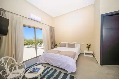 a bedroom with a bed and a large window at Villa Djamila Marrakech in Marrakech
