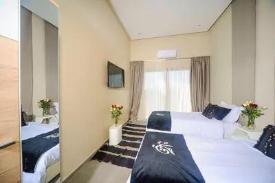 a hotel room with two beds and a mirror at Villa Djamila Marrakech in Marrakech
