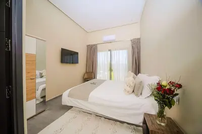 a bedroom with a bed with a vase of flowers on a table at Villa Djamila Marrakech in Marrakech