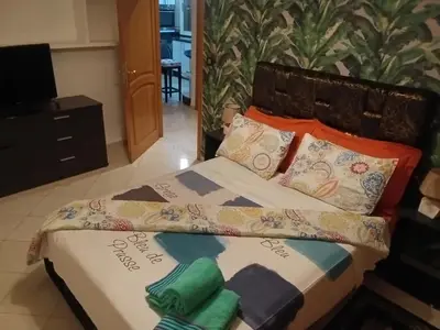 a bed with colorful pillows on it in a room at Appartement Suzette in Marrakech