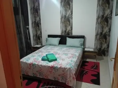 a bedroom with a bed with a green book on it at Appartement Suzette in Marrakech