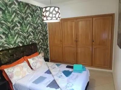 a bedroom with a bed and wooden cabinets at Appartement Suzette in Marrakech
