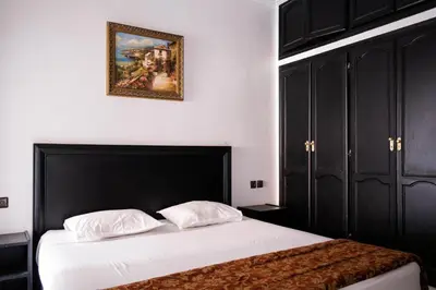 a bedroom with a bed and a picture on the wall at Hotel Apart LRB in Marrakech
