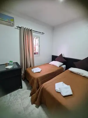 a hotel room with two beds and a window at Hotel Apart LRB in Marrakech