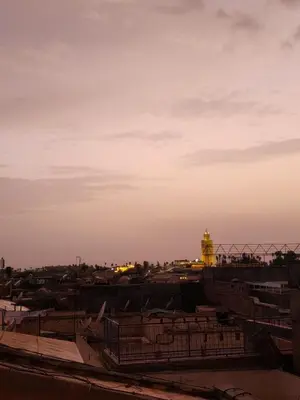 a view of a city at sunset with a clock tower at Riad Hostel ADI in Marrakech