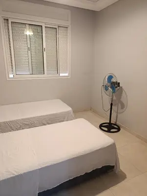 a white room with two beds and a fan at Chambre Marrakech 4 in Marrakech
