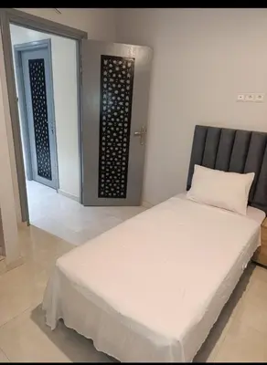 a white bed in a room with a door at Chambre Marrakech 4 in Marrakech