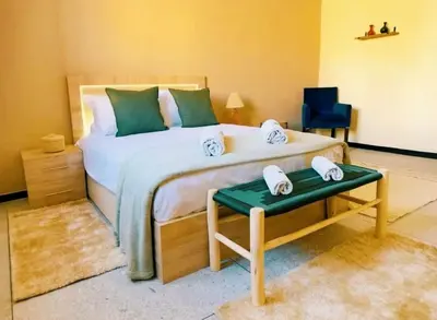 a bedroom with a large bed with two towels on it at Villa Issil Peaceful Haven in Marrakech in Marrakech