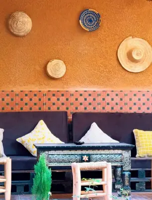 a couch sitting in front of a wall with hats at Villa Issil Peaceful Haven in Marrakech in Marrakech