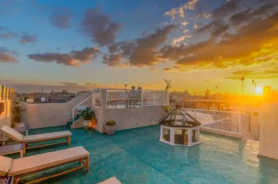 a balcony with a view of the city at sunset at Riad du Rabbin in Marrakech