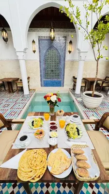 a table with food on it in a swimming pool at Riad du Rabbin in Marrakech